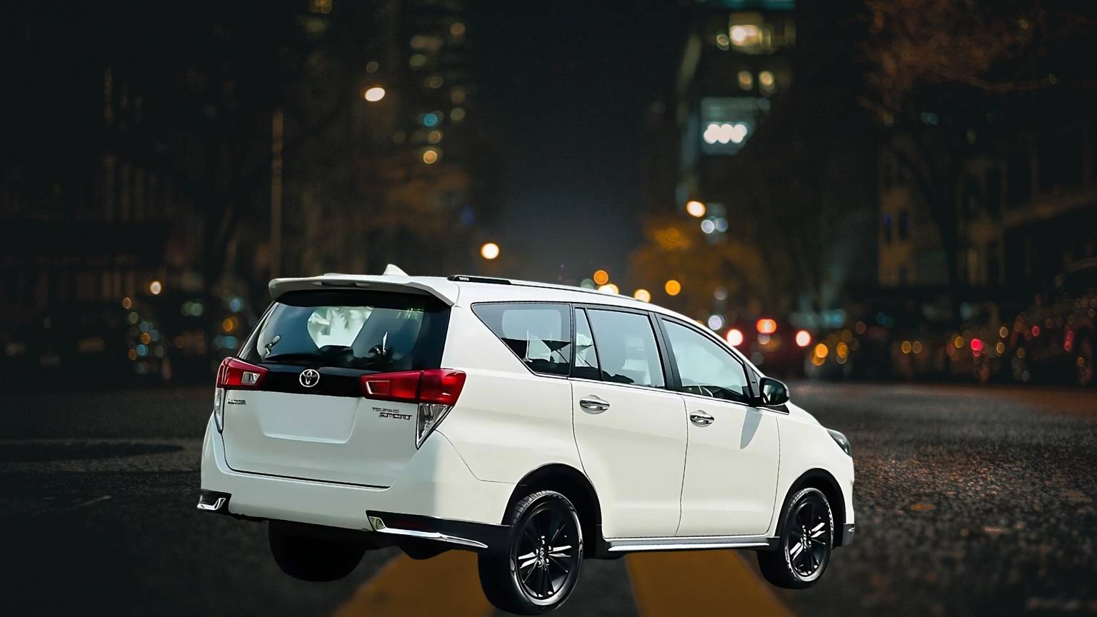 Need a ride in Madurai saw a white Toyota Innova cab driving on a city road at night. It would be great for booking a cab in Madurai or getting to and from the airport.