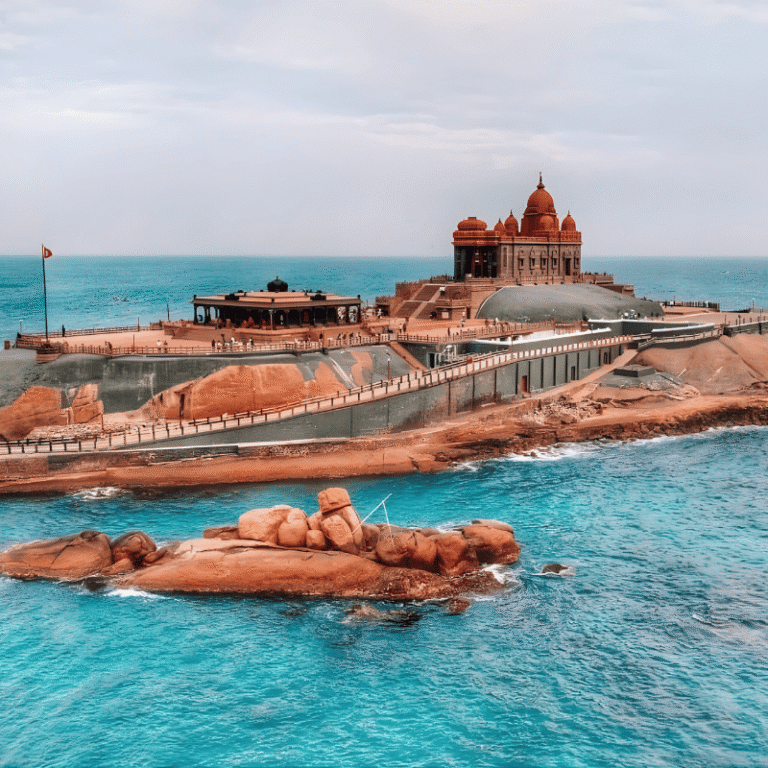 A bright, clear day at Kanyakumari offers a great view of the Vivekananda Rock Memorial. You can see the rocky island, the temple's design, and the ocean waves all around. It's the perfect shot for a Madurai to Kanyakumari cab booking website.